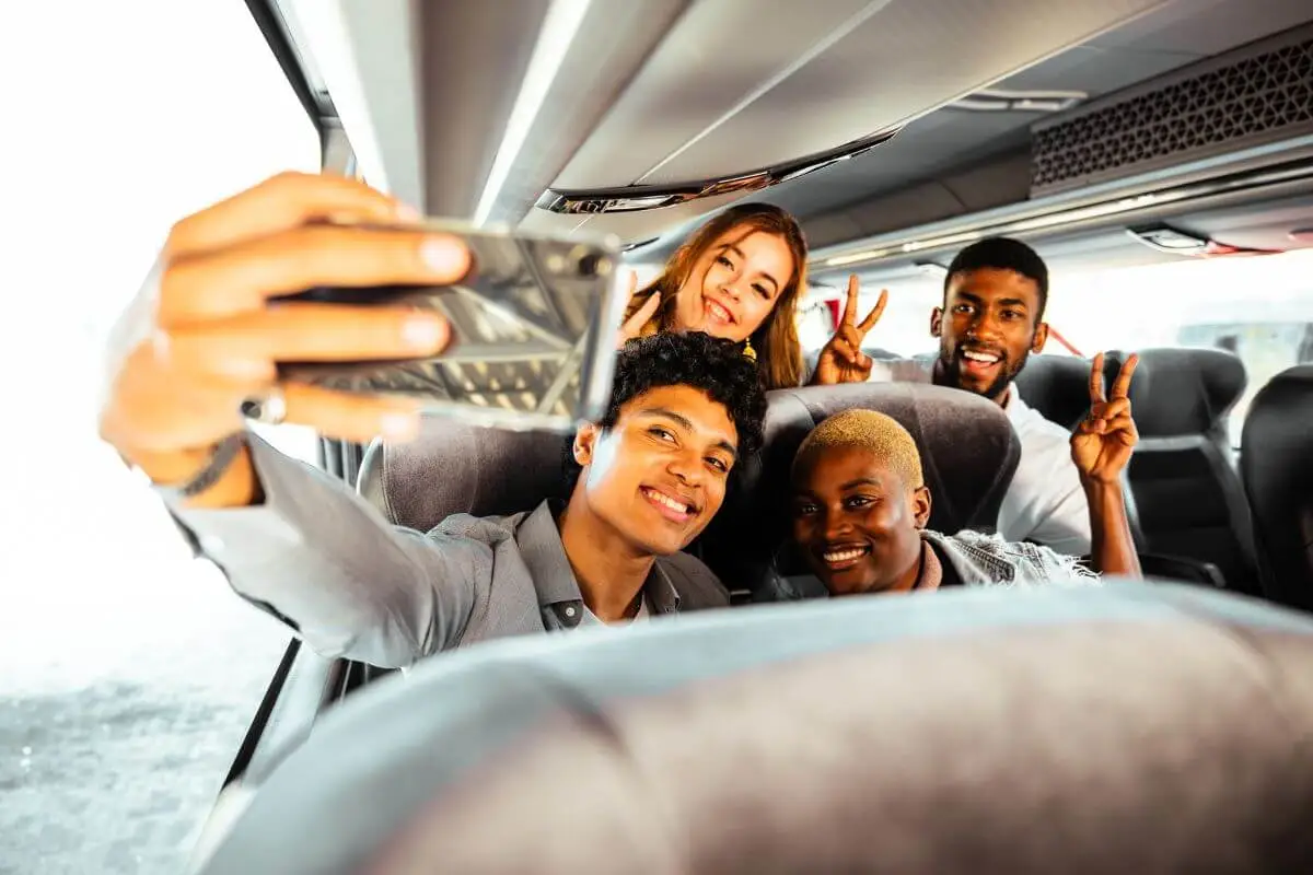 4 amigos tirando uma selfie dentro de um ônibus da BlaBlaCar