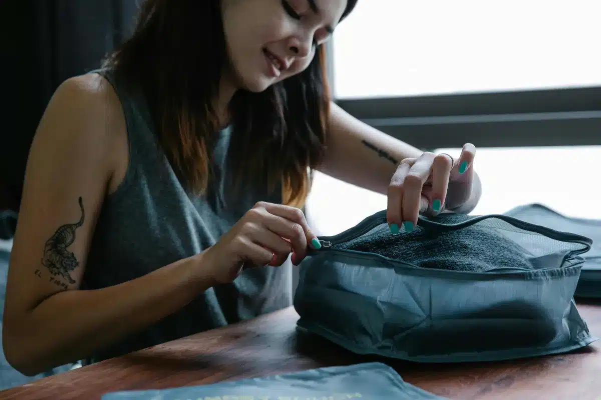 Kit para higiene pessoal: O que levar na mala para evitar perrengues Mulher fazendo seu kit de higiene pessoal